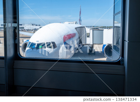 British airways boeing 777 airplane parked at an airport gate, connected to the jet bridge and waiting for passengers before departing for an international flight British airways boeing 777 airplane parked at an airport gate, connected to the jet bridge and waiting for passengers before departing for an international flight 138471334