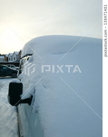 Snow covers a van in a parking lot as the sun rises on a cold winter morning Snow covers a van in a parking lot as the sun rises on a cold winter morning 138471481