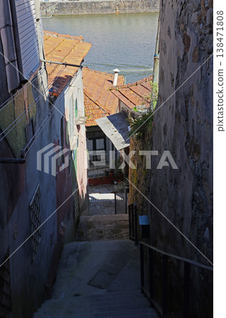 Narrow old street alley in Porto Portugal with stone walls and small houses. Medieval urban passage with historic architecture. Travel destination scene suitable for tourism guides 138471808
