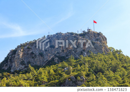 View of Chalysh mountain with Turkish flag in Kemer, Turkey View of Chalysh mountain with Turkish flag in Kemer, Turkey 138471823