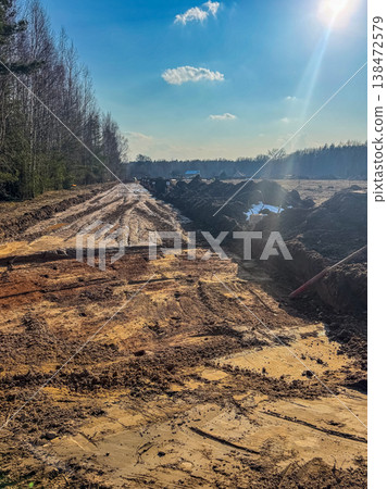 Construction of a new road or pipeline in a rural landscape on a sunny spring day. Construction of a new road or pipeline in a rural landscape on a sunny spring day. 138472579