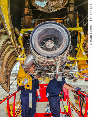Aviation mechanics installing an Auxiliary Power Unit APU into an aircraft. Teamwork in the aerospace industry. Aviation mechanics installing an Auxiliary Power Unit APU into an aircraft. Teamwork in the aerospace industry. 138472581