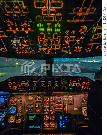 Pilot's view from an illuminated cockpit during a snowy night landing. Aviation and travel in challenging winter weather. 138472583