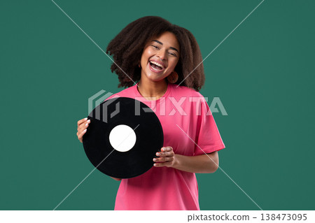 Pretty Woman Smiling With Vinyl Record Disc On green. Hobby, Music, Collection Pretty Woman Smiling With Vinyl Record Disc On green. Hobby, Music, Collection 138473095