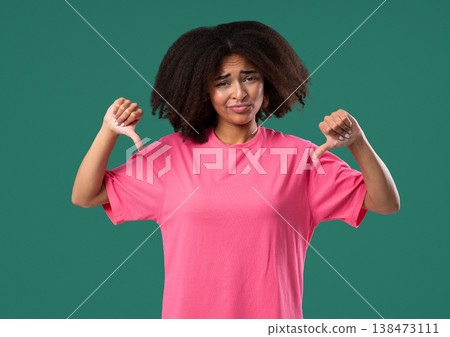 African Woman With Dislike Sign.stylish Lady Showing Thumbs-Down On Green Studio 138473111
