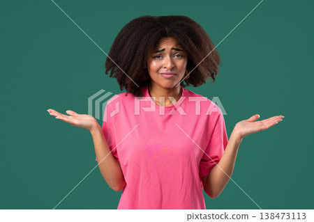 Confused african woman shrugs shoulders showing uncertainty,confusion,hesitation Confused african woman shrugs shoulders showing uncertainty,confusion,hesitation 138473113