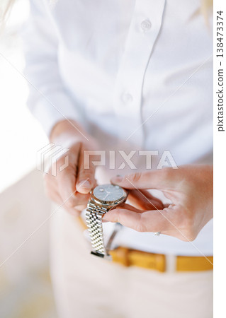 Closeup Of Person Adjusting Exquisite Silver Timepiece During Dawn Closeup Of Person Adjusting Exquisite Silver Timepiece During Dawn 138473374