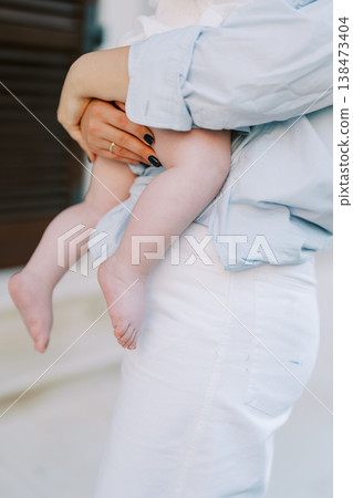 Parent Embraces Toddler Tightly Amid Sunny Outdoor Environment Parent Embraces Toddler Tightly Amid Sunny Outdoor Environment 138473404