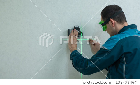 A man measures distance with a laser level. A man measures distance with a laser level. 138473464