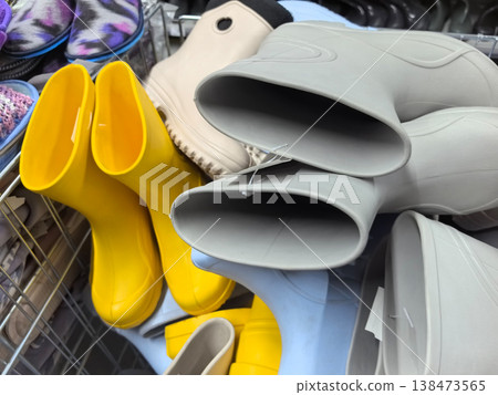 Bright yellow and gray rubber boots waiting for new adventures indoors Bright yellow and gray rubber boots waiting for new adventures indoors 138473565