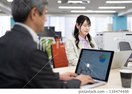 A man and a woman having a meeting while looking at their computer screens. 138474486