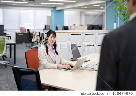 Smiling female employees chatting in the office Smiling female employees chatting in the office 138474970