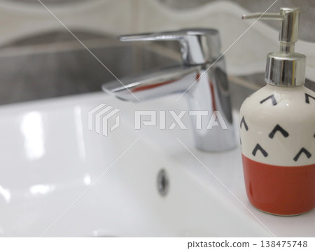 Soap dispenser on bathroom sink 138475748