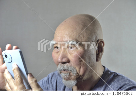 A bearded old man with a smartphone 138475862