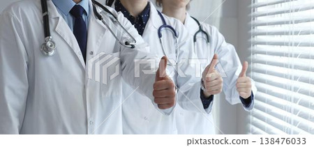 Medical team showing thumbs up gestures, symbolizing healthcare success, collaboration, good results, excellent medical service, and professional doctor approval 138476033