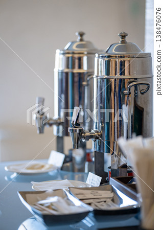 Self-service coffee station with shiny stainless steel beverage urns 138476076