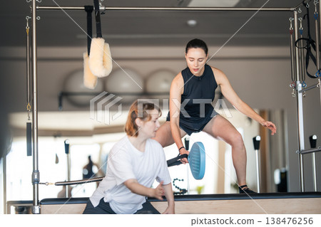 Women training active pilates exercises in studio 138476256