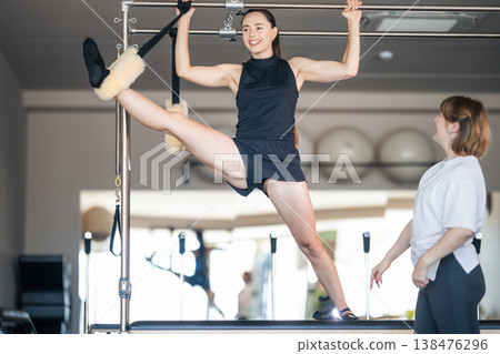 Woman exercising pilates on reformer achieving full flexibility 138476296