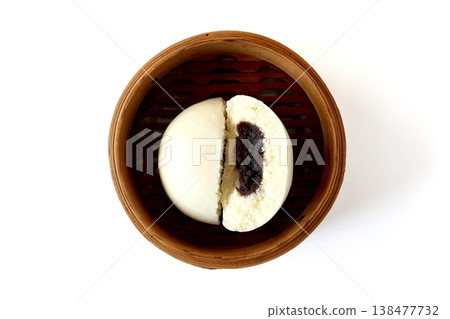A sesame paste bun in a steamer basket, viewed from directly above against a white background. A sesame paste bun in a steamer basket, viewed from directly above against a white background. 138477732