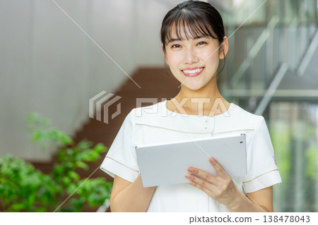 A woman carrying a tablet 138478043