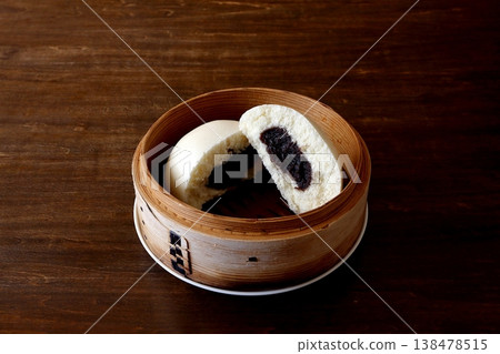 Sesame paste buns in a steamer basket in the background of the table Sesame paste buns in a steamer basket in the background of the table 138478515