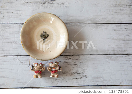 Okinawan pottery Shisa placed on natural white wood grain Okinawan pottery Shisa placed on natural white wood grain 138478801