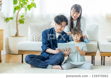 一家人在客廳看平板電腦 138478982