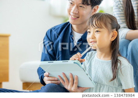 一家人在客廳看平板電腦 138478984