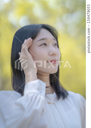 A young woman shields her eyes from the bright sunlight; natural light; refreshing; beauty image. A young woman shields her eyes from the bright sunlight; natural light; refreshing; beauty image. 138479055