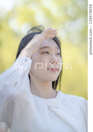 年輕女子用手遮擋刺眼的陽光；自然光；清新；美麗的畫面。 138479058