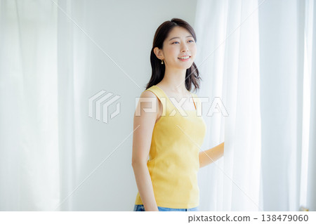 Woman opening curtain Woman opening curtain 138479060