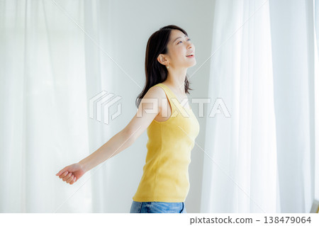 Woman opening curtain Woman opening curtain 138479064