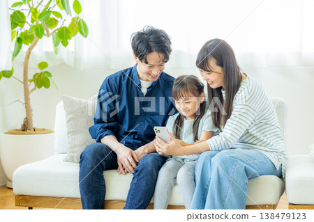 一家人在客廳裡看智能手機 138479123