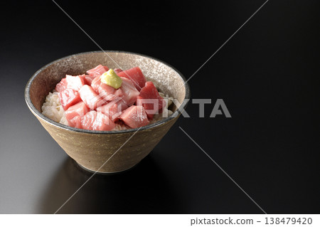 A bowl of diced tuna photographed alone against a black background. A bowl of diced tuna photographed alone against a black background. 138479420