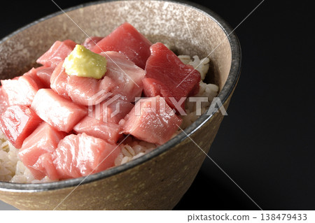 A bowl of diced tuna photographed alone against a black background. A bowl of diced tuna photographed alone against a black background. 138479433