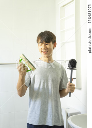 Asian young teen boy cleaning bathroom at home. 138481973