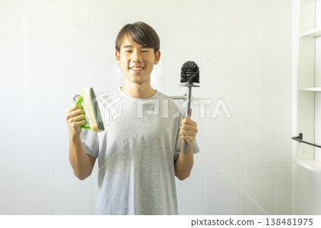 Asian young teen boy cleaning bathroom at home. Asian young teen boy cleaning bathroom at home. 138481975