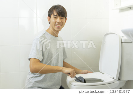 Asian young teen boy cleaning bathroom at home. Asian young teen boy cleaning bathroom at home. 138481977