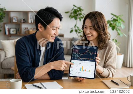 一對夫婦正在使用平板電腦討論資產管理；圖片顯示了投資和家庭預算管理。 138482002