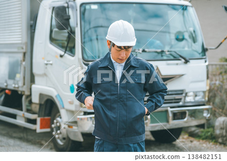 Truck driver fumbling in his pockets 138482151