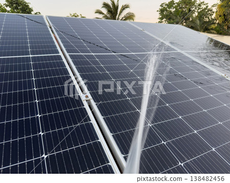 Water is sprayed on solar panels to clean them in a sunny location 138482456