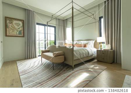 Interior view of King Size Canopy Bed Frame with pillows in elegant bedroom. Honeymoon suite bedroom in pastel and pink color Interior view of King Size Canopy Bed Frame with pillows in elegant bedroom. Honeymoon suite bedroom in pastel and pink color 138482618