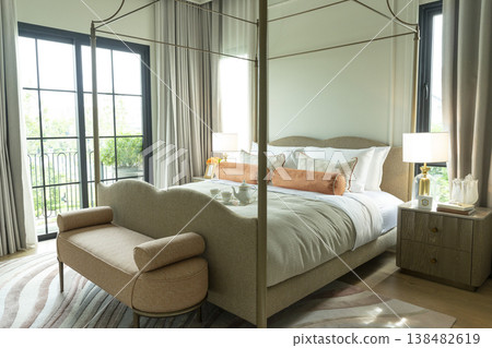 Interior view of King Size Canopy Bed Frame with pillows in elegant bedroom. Honeymoon suite bedroom in pastel and pink color Interior view of King Size Canopy Bed Frame with pillows in elegant bedroom. Honeymoon suite bedroom in pastel and pink color 138482619