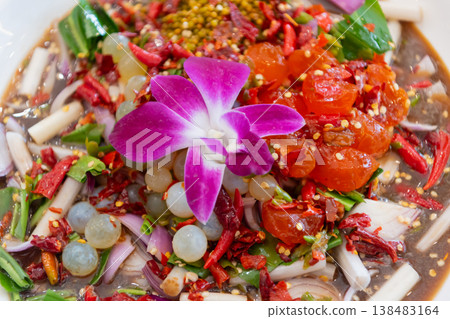 Spicy Thai salad with salmon cherry tomatoes herbs chili and lime dressing topped with orchid flower vibrant colorful cuisine fresh and flavorful dish Spicy Thai salad with salmon cherry tomatoes herbs chili and lime dressing topped with orchid flower vibrant colorful cuisine fresh and flavorful dish 138483164