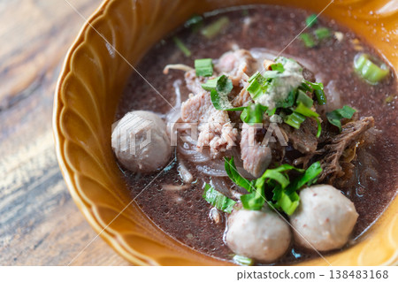 Thai noodle soup with pork slices meatballs and herbs in rich broth served in bowl traditional street food flavorful and warm comfort meal Thai noodle soup with pork slices meatballs and herbs in rich broth served in bowl traditional street food flavorful and warm comfort meal 138483168