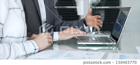 Business partners discussing financial data on laptop screen during corporate meeting, analyzing charts for strategy. Business-people concept 138483770