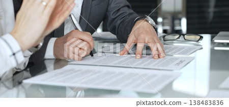 Business partners discussing contract terms at an office meeting, making agreement and shaking hands on a deal. Business-people concept Business partners discussing contract terms at an office meeting, making agreement and shaking hands on a deal. Business-people concept 138483836