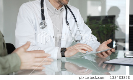 Doctor man discussing medical information with patient woman using digital tablet during consultation, healthcare technology concept. Medicine, health care and science concept 138483838