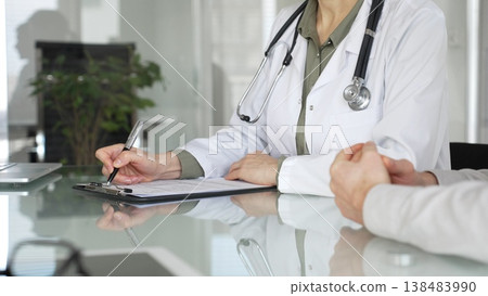 Doctor woman discussing medical information with patient during a healthcare consultation in a professional clinic office, close up. Medicine, health care and science concept 138483990