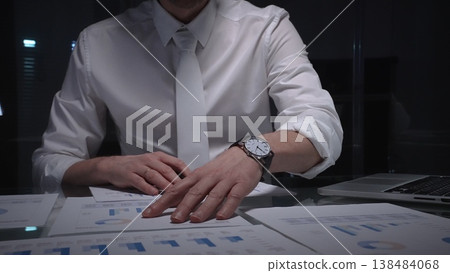 Business professional analyzing financial data with charts and reports on desk, working late in dark office. Audit and overworking concepts Business professional analyzing financial data with charts and reports on desk, working late in dark office. Audit and overworking concepts 138484068